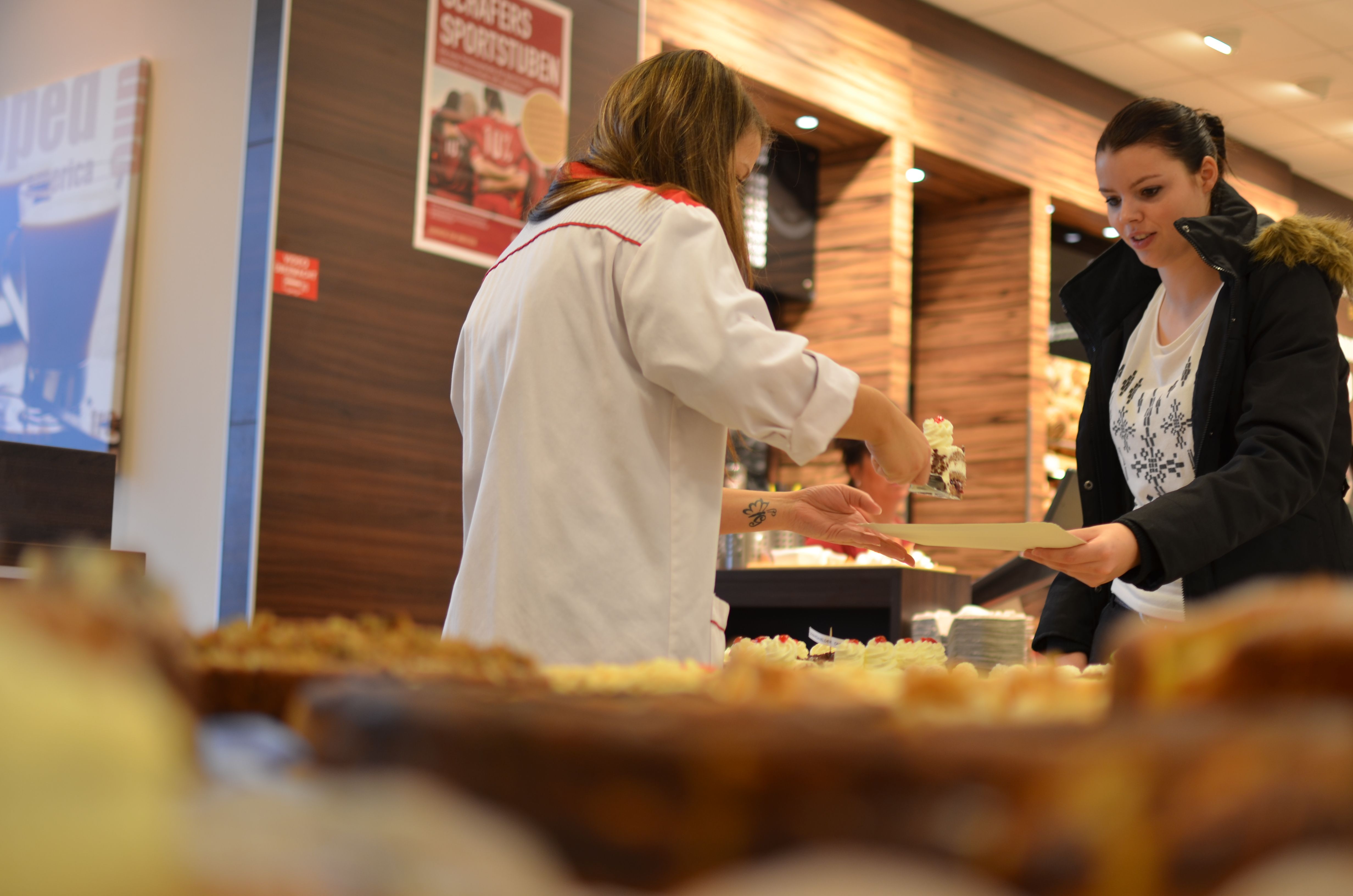 Mitarbeiter verkaufen Kuchen für guten Zweck
